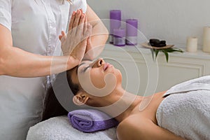 Woman beautician doctor make head massage in spa wellness center