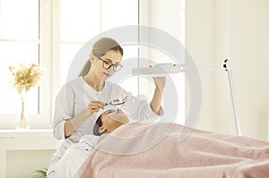 Woman beautician make skincare procedures for client in salon