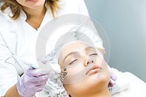 Woman at a beautician& x27;s appointment. Non-surgical face lifting. microcurrent facial therapy