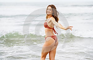 Woman with beautiful body enjoying her bath on the beach