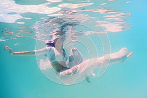 Woman beautiful body swim underwater in white dress