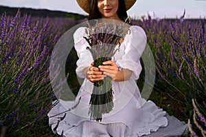 Woman with beautiful bouquet in lavender field, closeup