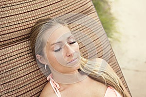 Woman with beautiful eyelashes lounging by the pool outdoors