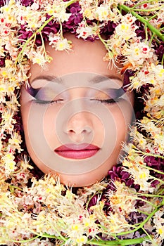 Woman beautiful face with chestnut flower frame