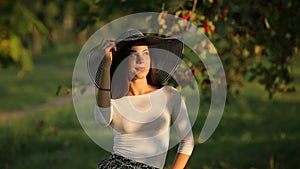 woman with beautiful face sunbathing in warm summer park at sunset