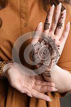 Woman with beautiful henna tattoo on hand, closeup. Traditional mehndi