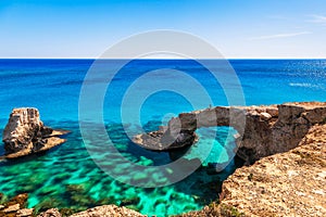 Woman on the beautiful natural rock arch near of Ayia Napa, Cavo Greco and Protaras on Cyprus island, Mediterranean Sea. Legendary photo