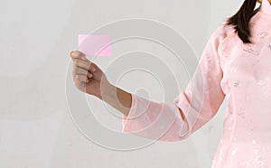 Woman beautiful pink dress hands holding a pink business visit card
