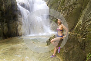 Woman beautiful sit relax in waterfall with bikini