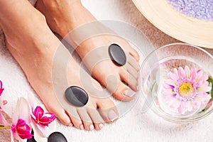 Woman with beautiful skin of feet and fresh manicure doing spa treatments for her feet.