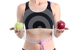 Woman with beautiful slender figure with centimeter at waist holds two red and green apples in hands closeup