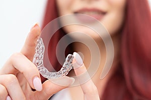 Girl with a beautiful smile shows a transparent mouth guard photo