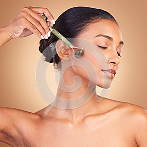 Woman, beauty and derma roller with face, calm with facial massage and skincare on studio background. Cosmetic tools