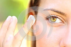 Woman with beauty eyes applying moisturizer