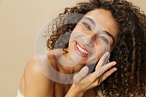 Woman beauty face close-up applying anti-aging moisturizer with fingers of her hand, skin health nails and hair, hair