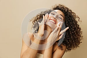 Woman beauty face close-up applying foam to wash and cleanse skin with fingers of her hand, nail and hair health, hair