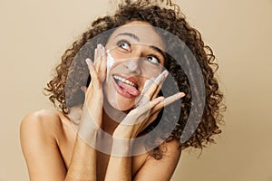 Woman beauty face close-up applying foam to wash and cleanse skin with fingers of her hand, nail and hair health, hair