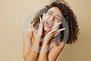 Woman beauty face close-up applying foam to wash and cleanse skin with fingers of her hand, nail and hair health, hair