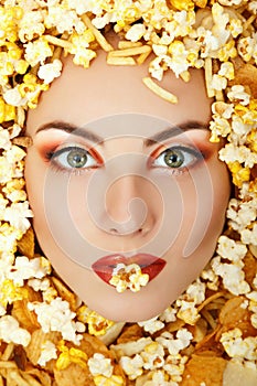 Woman beauty face with unhealth eating fast food popcorn potato photo