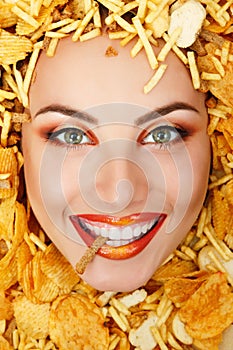 Woman beauty face with unhealth eating fast food potato chips photo
