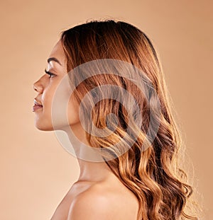 Woman, beauty and hair care profile with healthy growth or shine and strong texture on brown background. Aesthetic