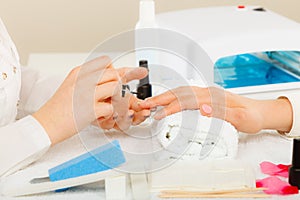 Woman in beauty salon getting manicure done.