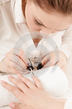 Woman in beauty salon getting manicure done.