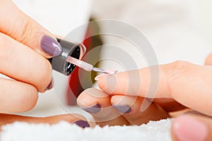 Woman in beauty salon getting manicure done.