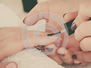 Woman in beauty salon getting manicure done.