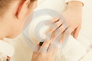 Woman in beauty salon getting manicure done.