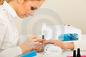 Woman in beauty salon getting manicure done.