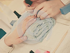 Woman in beauty salon getting manicure done.