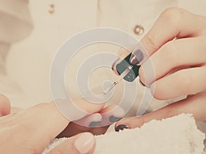 Woman in beauty salon getting manicure done.