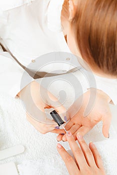 Woman in beauty salon getting manicure done