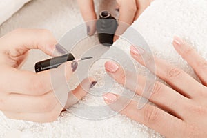 Woman in beauty salon getting manicure done.