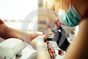 Woman at beauty salon receiving manicure treatment