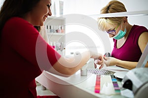Woman at beauty salon receiving manicure treatment
