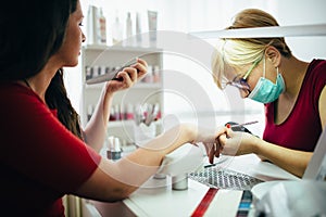 Woman at beauty salon receiving manicure treatment