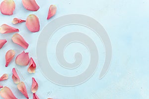 Woman beauty salon and spa procedures concept with pink rose petals top view at light blue background. Copy space for