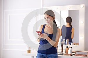 Woman beauty salon using and looking at mobile phone