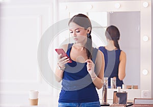 Woman beauty salon using and looking at mobile phone