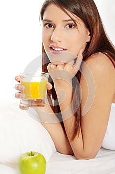 Woman in bed drinking orange juice