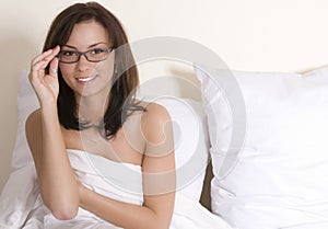 Woman on bed with glasses