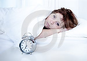 Woman in bed with insomnia that can't sleep with alarm clock