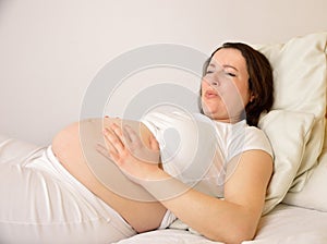 Woman on bed with pregnancy pains