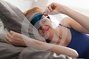 Woman In Bed With Sleep Mask On Eyes Waking Up