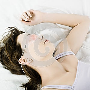Woman in bed sleeping with cryogenic mask