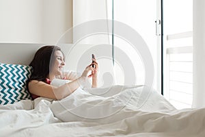 Woman in bed with smartphone