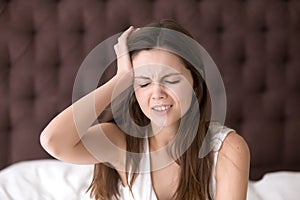 Woman in bed suffering from headache in morning