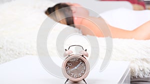 Woman in bed turns off the alarm clock in the morning. Close up alarm clock, selective focus. New day start concept